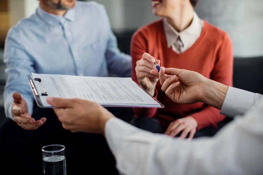 Una persona revisando documentos de derecho familiar con Inés en la oficina de Quality Paralegal Services