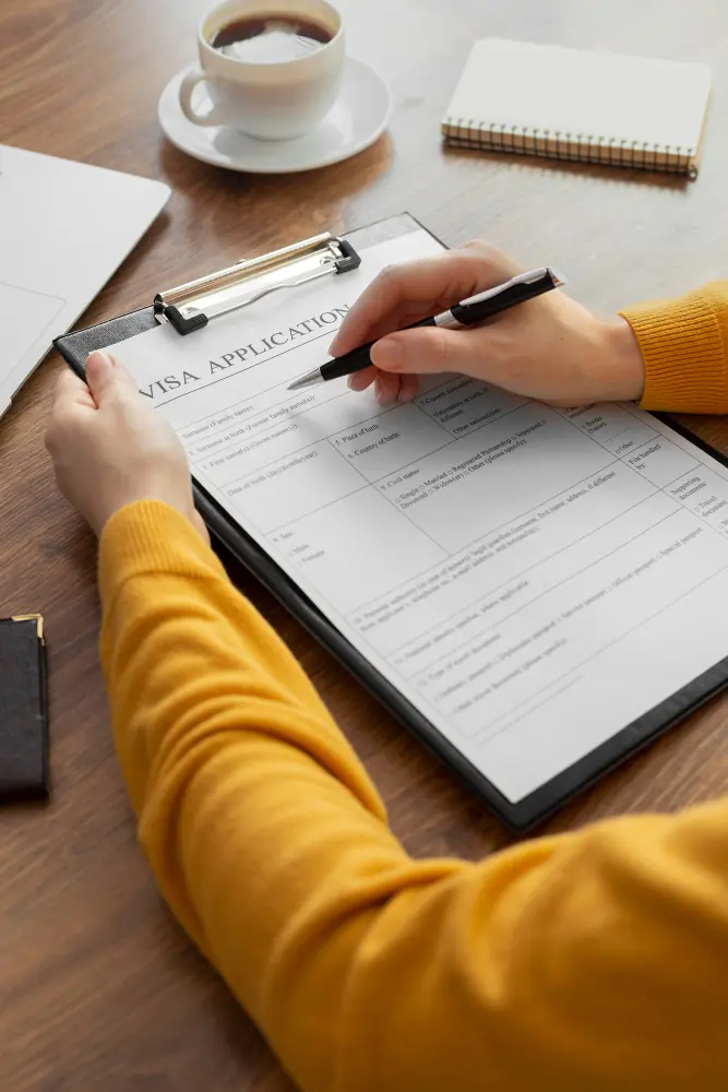 Una persona llenando una solicitud de visa sobre una tablilla con sujetapapeles