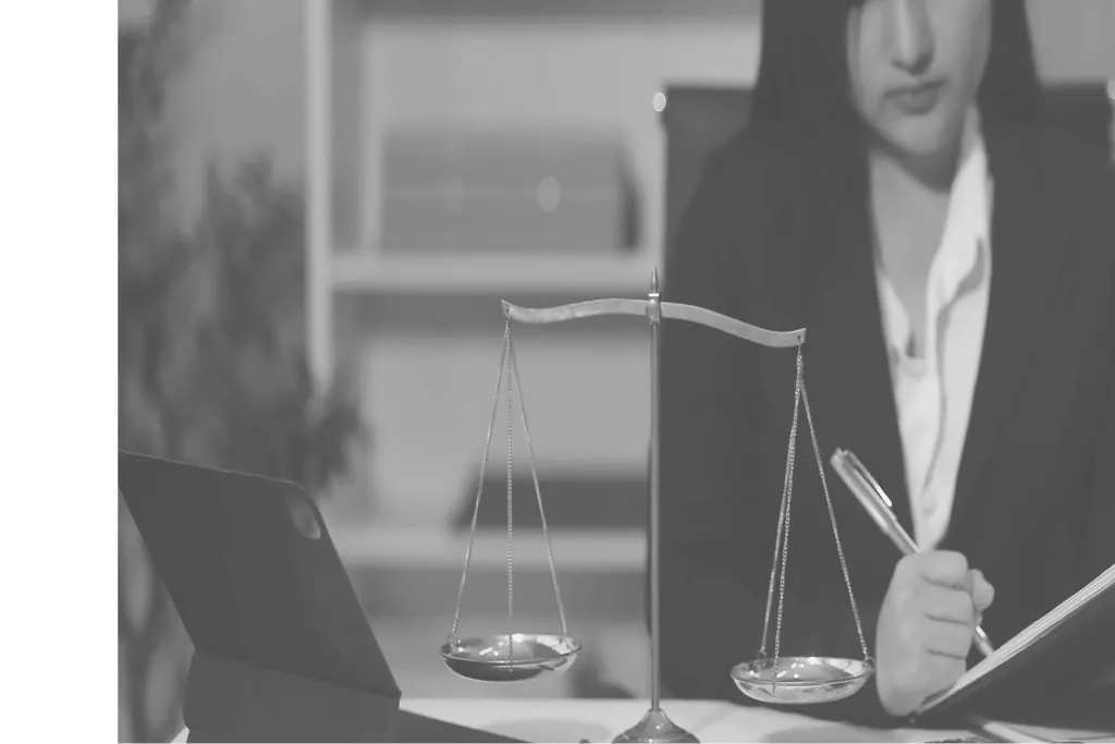 Una mujer en un escritorio con una balanza de la justicia de latón
